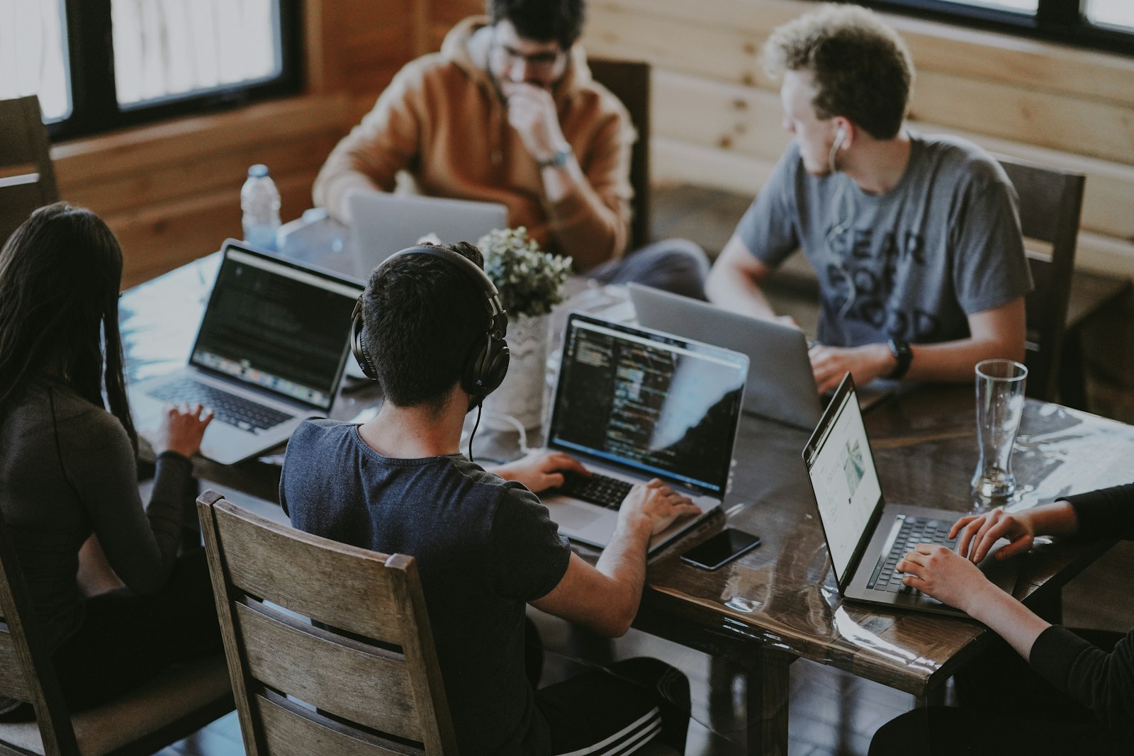 A development team working together around a table full of laptops